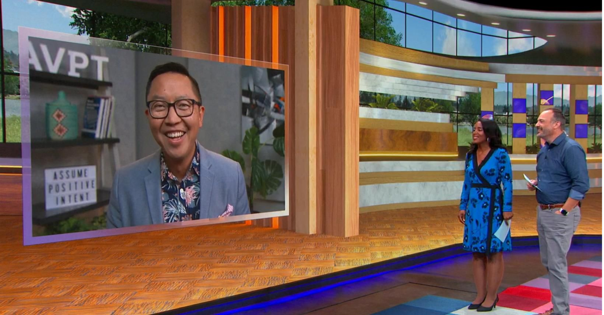 Dux appearing on a television studio screen beside two interview hosts